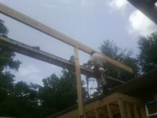 Carpenter setting a ridge beam over a new addition frame — Ice Dam Removal by Roofing Brothers in Apple River