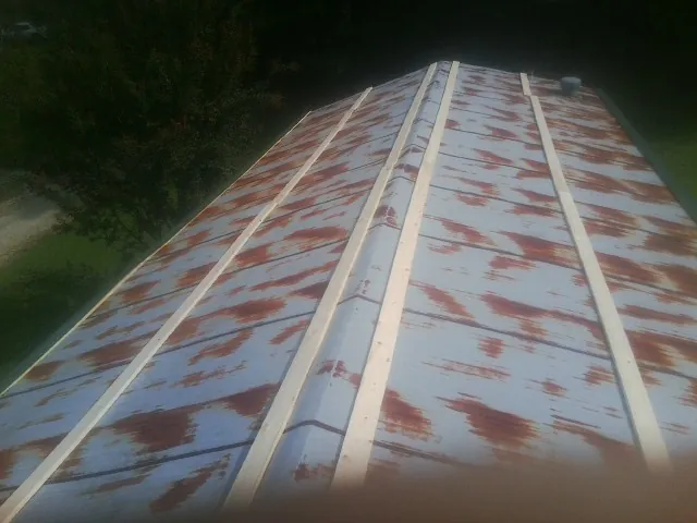 Rusted metal roof panels with new wood purlins before replacement — Storm Damage Roof Repair in Apple River by Roofing Brothers