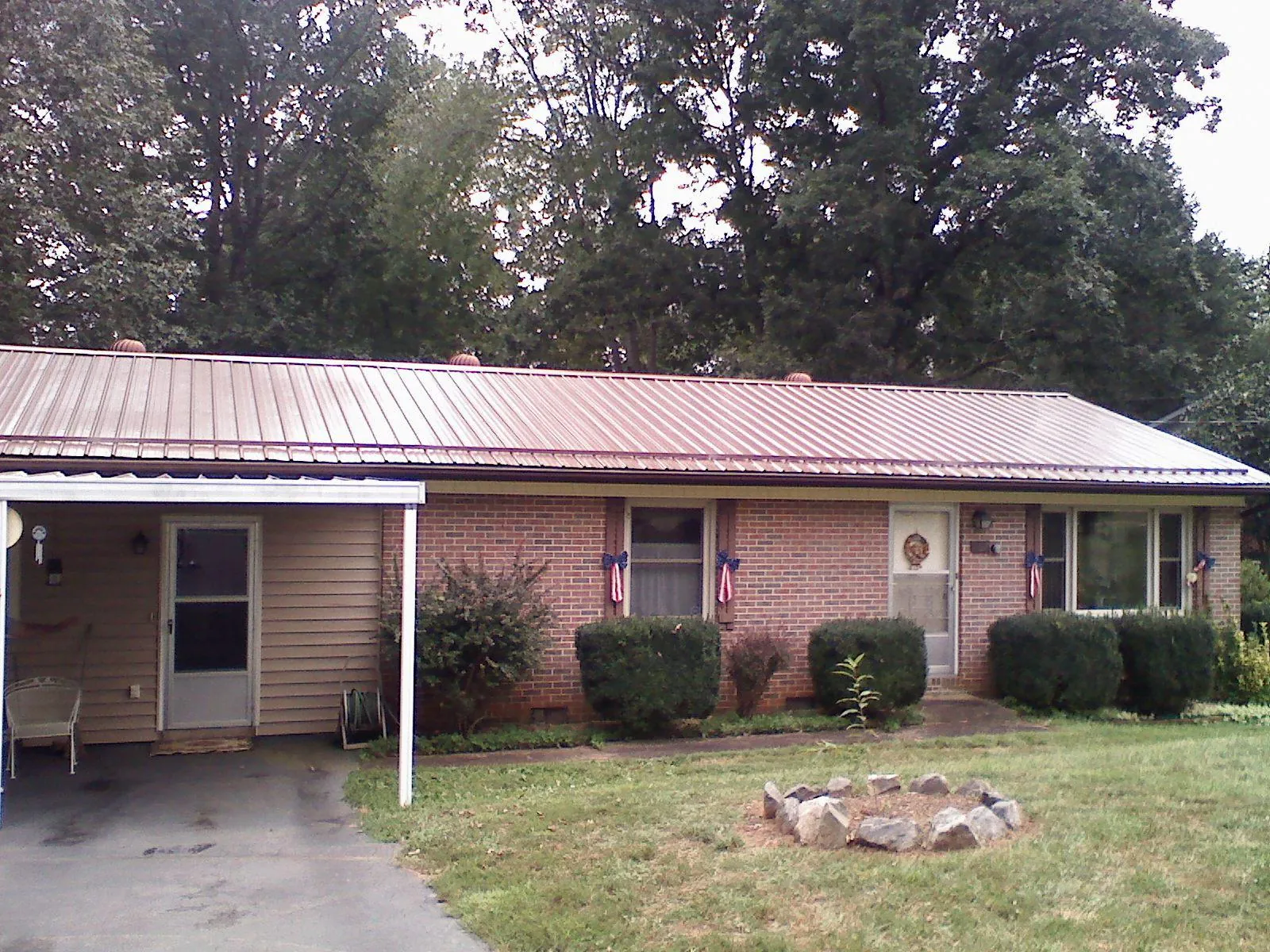 Bronze metal roof and carport on a brick ranch home — Roof Repair work by our crew in Apple River