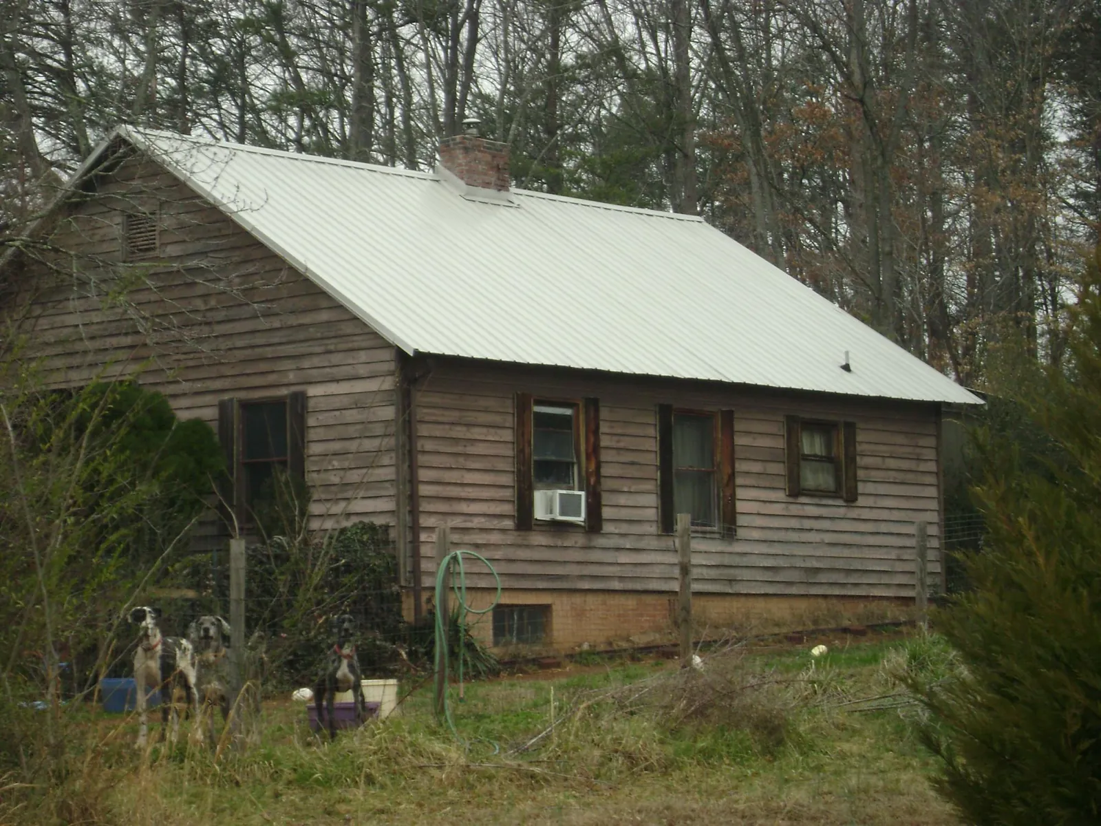 White metal roof on an old wood sided farmhouse, from a Metal Roof Installation job in Apple River